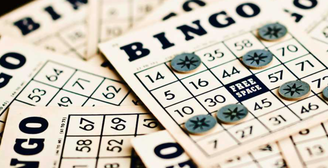 A set of bingo cards and cardboard markers blocking out called bingo numbers.