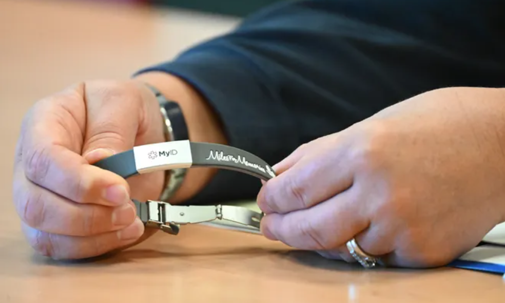 A closeup of a person holding a medical bracelet for the CARES ID bracelet program.