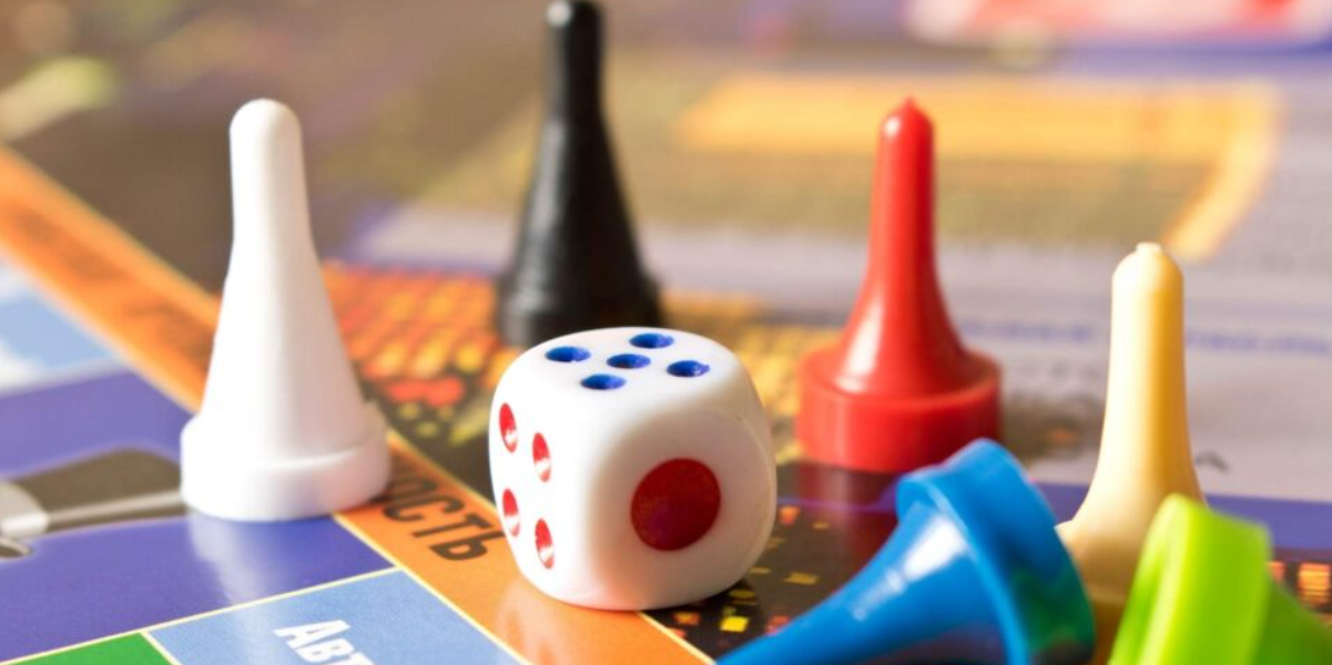 A set of character tokens, numbered dice and game boards setup on a game table.