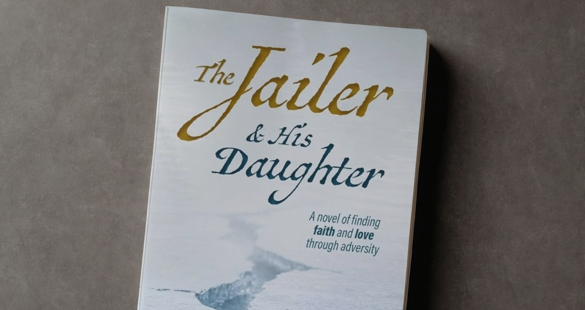 An image of a book on a table titled "The Jailer & His Daughter - A novel of finding Faith and Love through adversity" by Kirsten L Klassen.