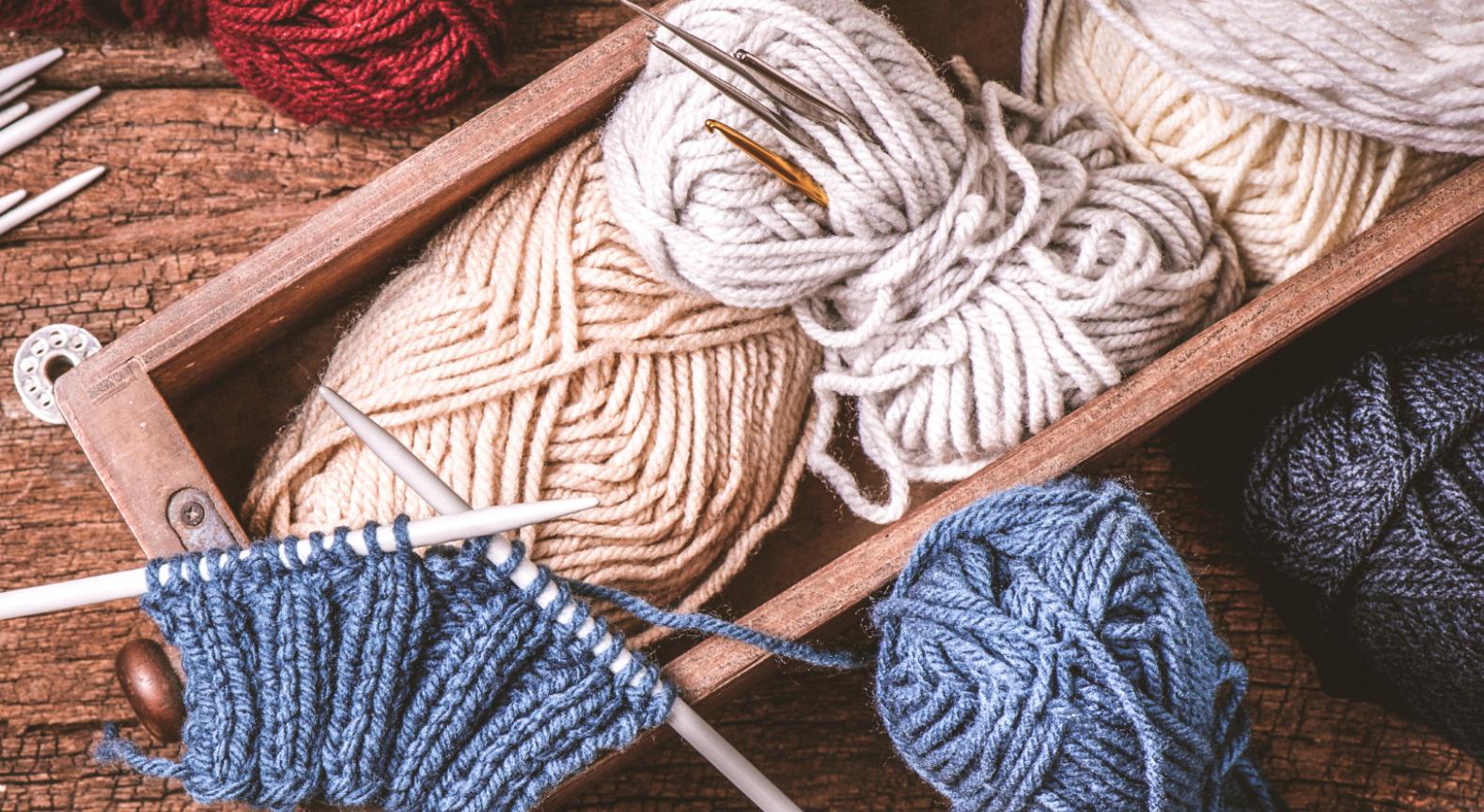 The image of a collection of knitting yarns and crocheting needles of all colors and textures.