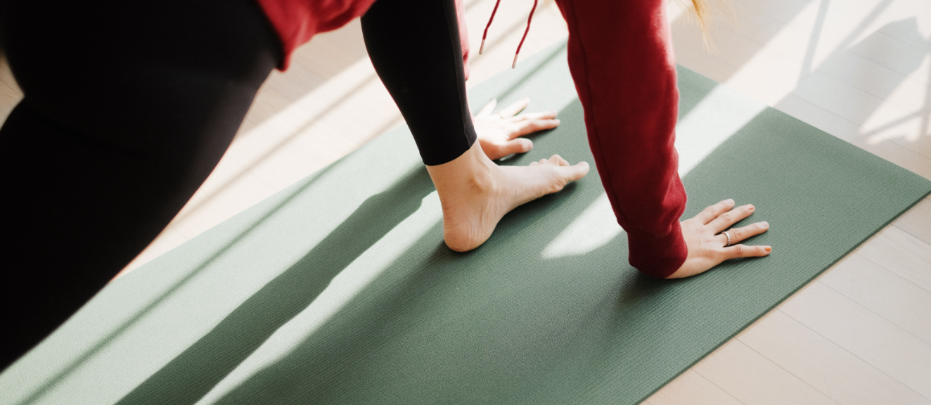 A person doing Pilates-style stretching on a yoga mat.